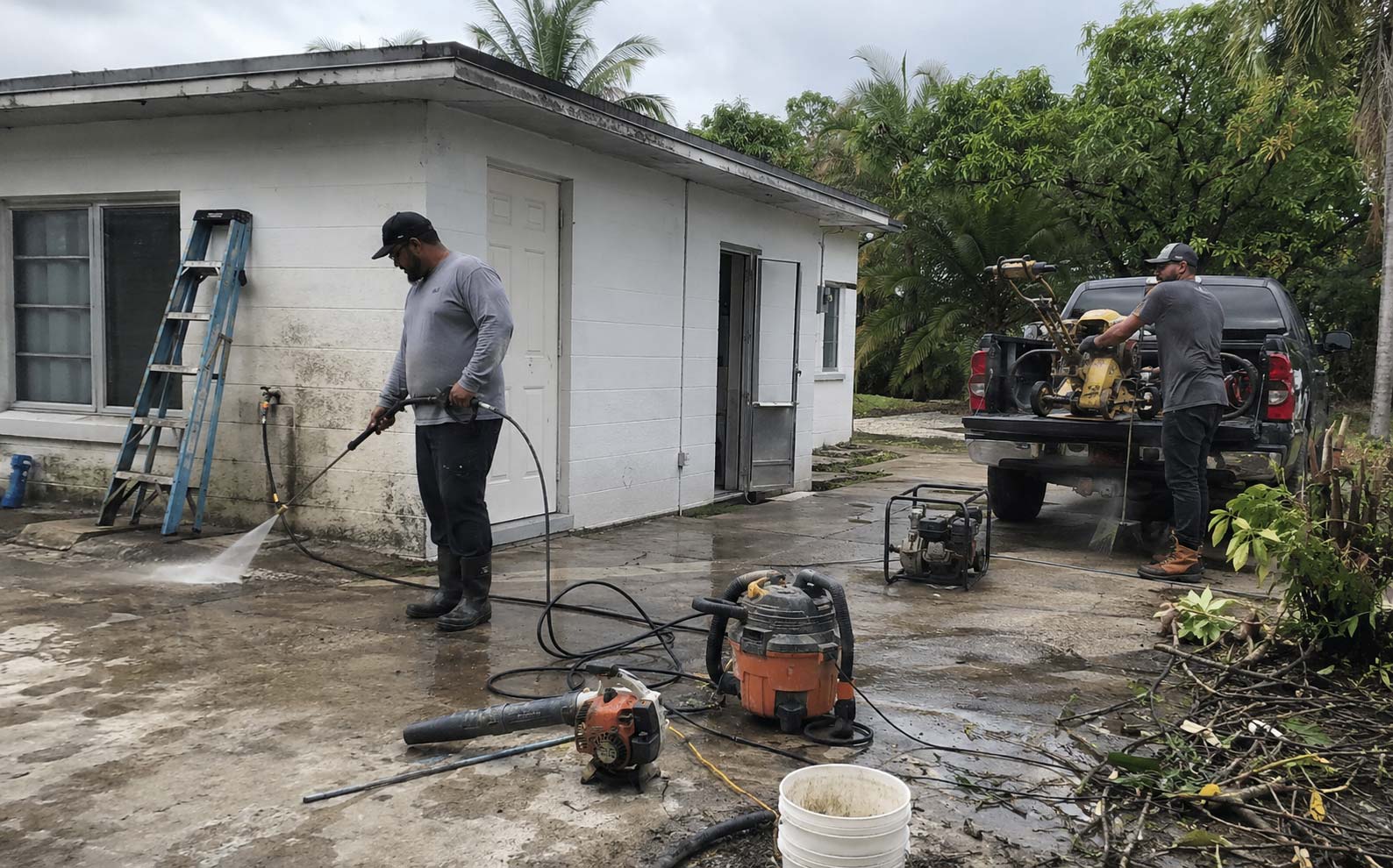 Miami contractors using locally rented pressure-washing, drainage and property-maintenance equipment at a South Florida property